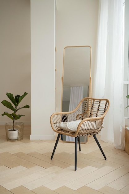 Fauteuil en rotin en osier et miroir dans le salon à la maison