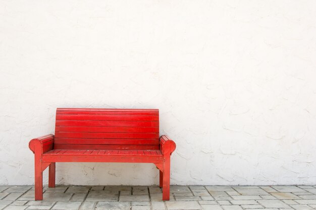 Fauteuil rouge mur blanc et sol gris