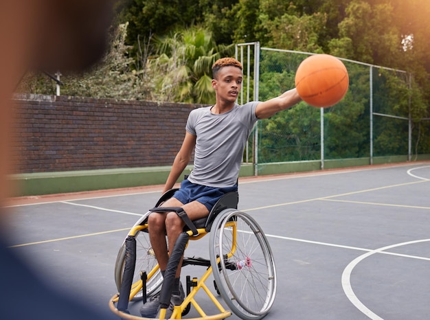 Fauteuil roulant de basket-ball et homme avec ballon de sport sur un terrain extérieur pour l'entraînement physique et l'exercice cardio et personne handicapée dans un parc pour l'entraînement de jeu et le plaisir du week-end ou le match actif