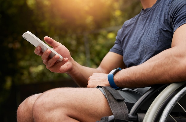 Fauteuil roulant téléphonique et mains d'une personne handicapée en tapant sur le site Internet ou en ligne pour rechercher des informations d'assistance