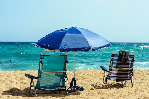 Des fauteuils de pont sur la plage contre un ciel dégagé