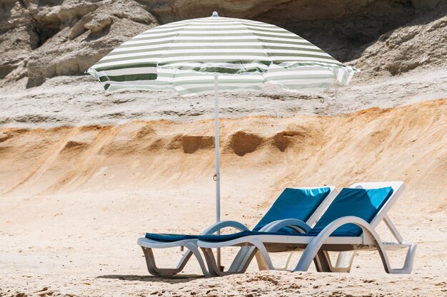 Photo des fauteuils sous parapluie à la plage