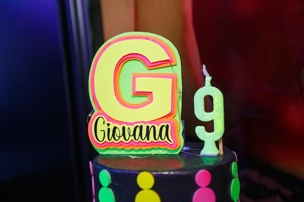 Faux gâteau avec le numéro neuf et le nom Giovana avec un thème néon à Rio de Janeiro