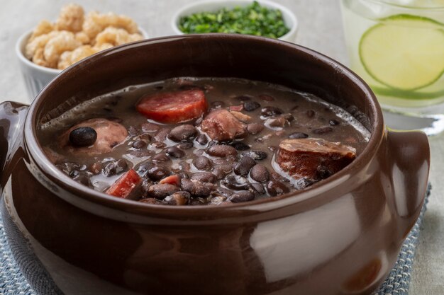 Feijoada brésilienne traditionnelle avec chou frisé, craquelins et caipirinha.