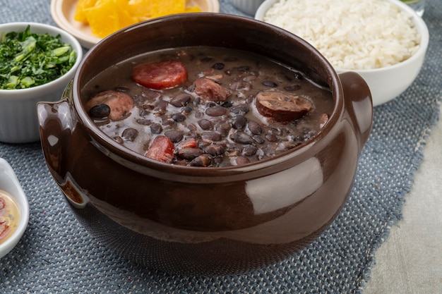 Feijoada brésilienne traditionnelle avec du riz, de l'orange, du chou frisé et du poivre.