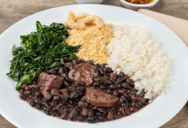 Feijoada brésilienne typique avec chou farofa au poivre de riz et crépitements