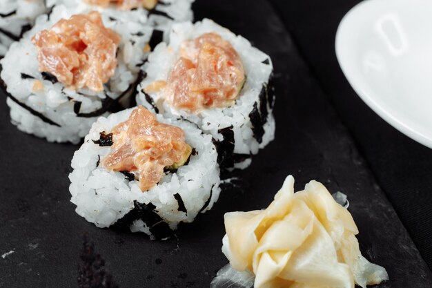 Felix roll avec sauce au thon wasabi et gingembre mariné sur un tableau noir.