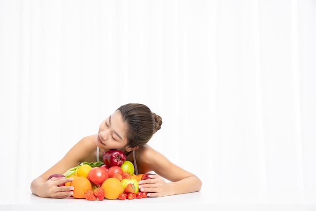 Femelle avec des fruits frais sur la table isolée sur le concept de régime de fond blanc