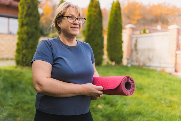 Femelle mature sur une retraite de yoga en plein air marchant le long du chemin à travers le camping