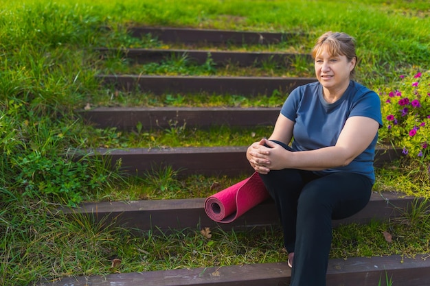 Femelle mature sur une retraite de yoga en plein air marchant le long du chemin à travers le camping