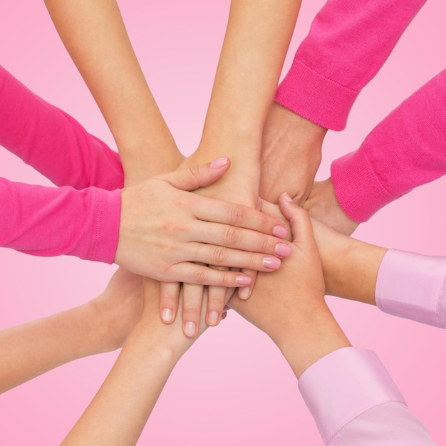 féminisme, pouvoir des femmes et concept de sensibilisation au cancer du sein - gros plan des mains des femmes les unes sur les autres sur fond blanc