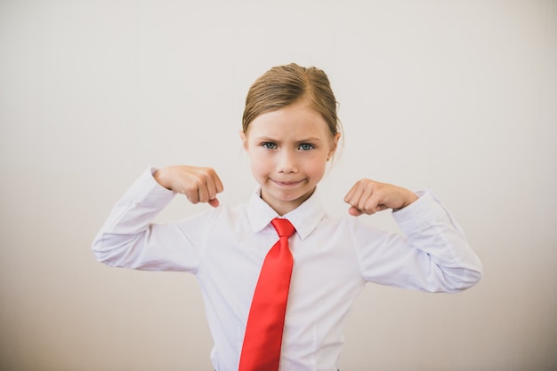 Féministe Confiante Positive Montrant Sa Force. Belle Fille Enfant Fléchissant Les Biceps Et Souriant à La Caméra. Concept De Féminisme