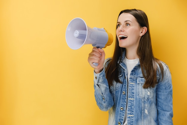 femme 20s criant dans un mégaphone serrant le poing