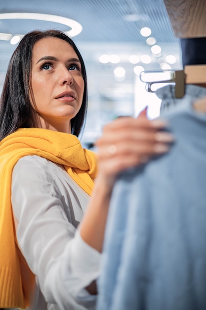 Photo une femme accro du shopping ravie attrapant des vêtements à une vente saisonnière de vendredi noir à prix réduit