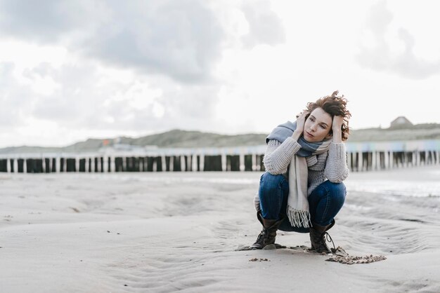 Femme accroupie sur la plage