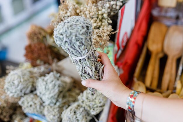 Photo une femme achetant un bouquet de sauge séchée au marché