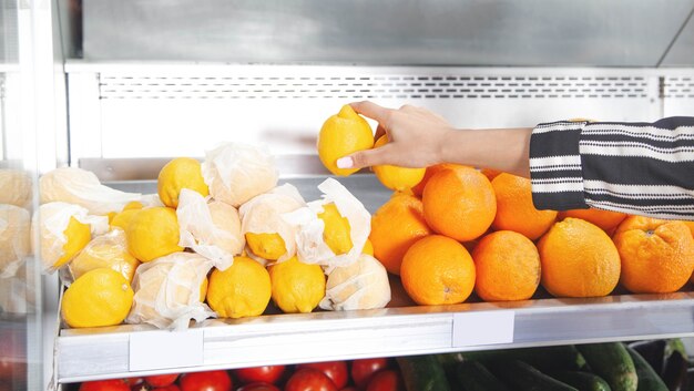 Femme achetant du citron au supermarché.