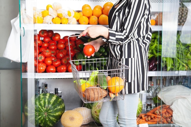 Femme achetant des tomates à l'épicerie