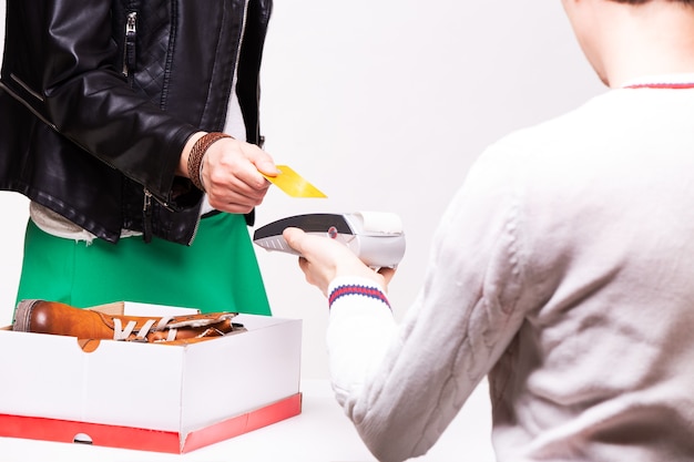 La femme achète des chaussures à la caisse de la boutique