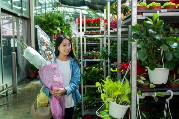 Une femme achète des fleurs dans le magasin.