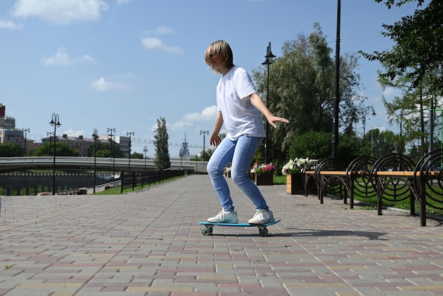 Une femme active d'âge moyen monte un skateboard sur une route ou une autoroute vide Une femme citadine ordinaire se détendant sur un skateboard après le travail Le concept d'un style de vie moderne