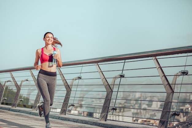 Femme active courant sur le pont le matin