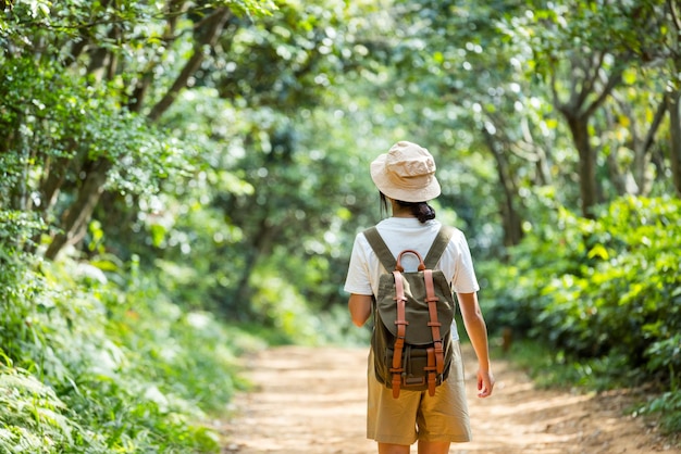 Photo une femme active fait de la randonnée et se promène le long d'un sentier dans la forêt.