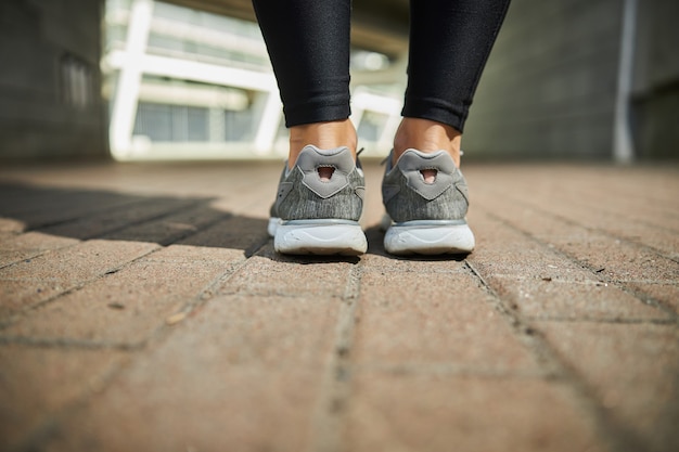 Femme active portant des baskets confortables tout en se préparant à courir sur de longues distances