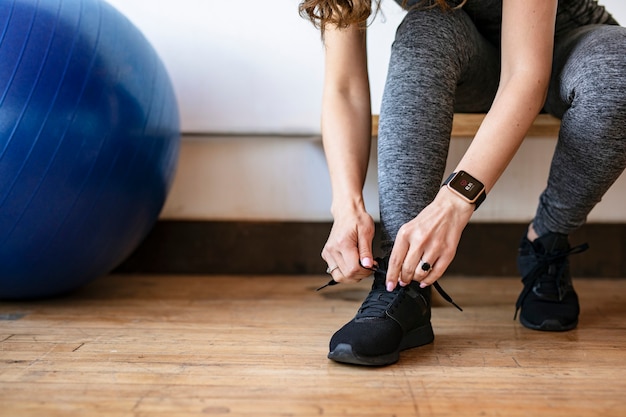 Femme Active Portant Une Smartwatch Attachant Ses Lacets