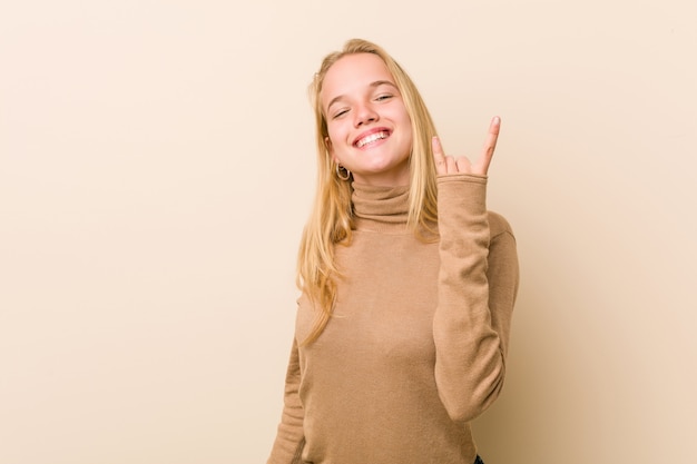 Femme adolescente mignonne et naturelle montrant un geste de cornes comme un concept de révolution.