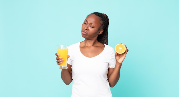 Femme adulte afro-américaine noire. notion de jus d'orange