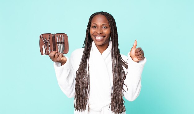 Femme adulte afro-américaine noire portant un peignoir et tenant un sac de maquillage avec des outils de nains