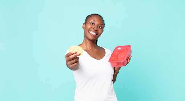 Femme adulte afro-américaine noire tenant un tupperware