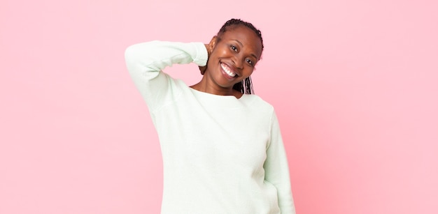 femme adulte afro noire riant joyeusement et en toute confiance avec un sourire décontracté, heureux et amical