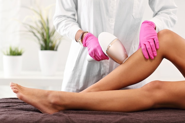 Femme adulte ayant l'épilation au laser dans un salon de beauté professionnel