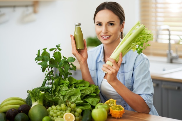 femme adulte en bonne santé avec de la nourriture verte dans la cuisine