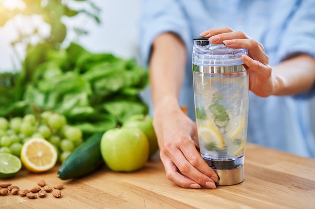 femme adulte en bonne santé avec de la nourriture verte dans la cuisine