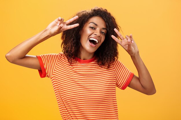 Une femme adulte debout sur un fond jaune