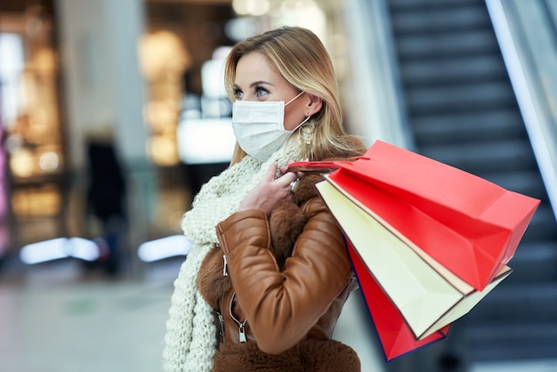 femme adulte faisant du shopping dans un centre commercial portant un masque, concept de coronavirus