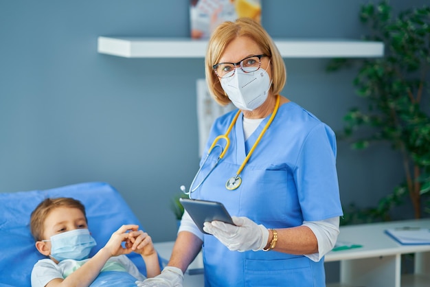 Femme adulte et jeune patient dans son lit d'hôpital. Photo de haute qualité