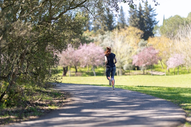 Une femme adulte en leggings jogging sur la nature