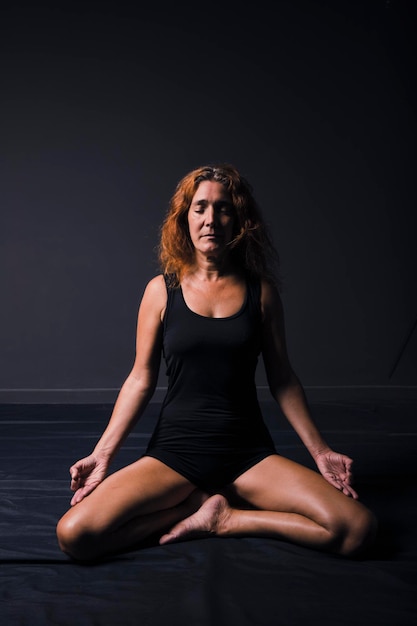Femme adulte en méditation pose dans un studio shot