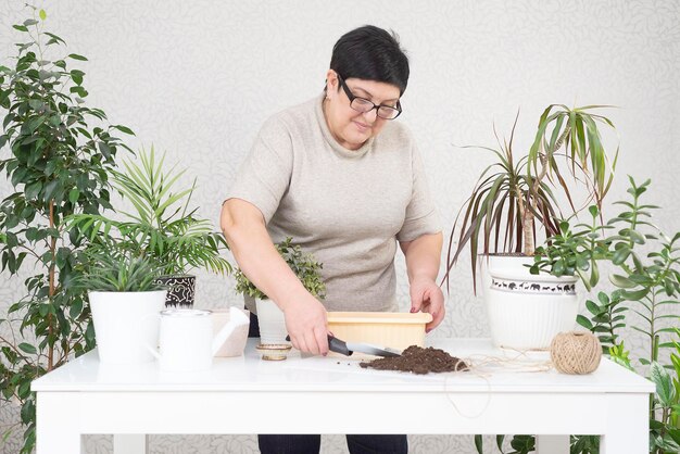 Une femme adulte plantant des semis de fleurs