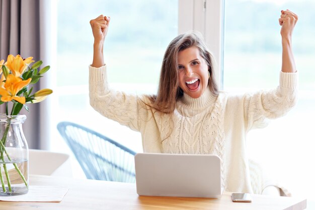 Femme adulte portant un pull chaud et travaillant à la maison un jour d'automne