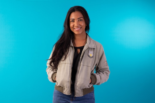 Femme adulte portant une veste décontractée faisant des expressions faciales en photo de studio avec fond bleu