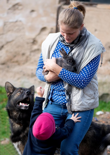 Photo une femme adulte porte un lapin alors qu'elle se tient dans le parc.