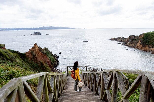 Femme adulte avec un sac à dos en cuir près de la côte