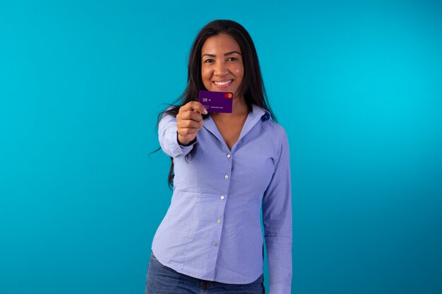 Femme adulte en tenue de soirée, vêtue d'une chemise bleue et d'un jean en photo de studio avec fond bleu.