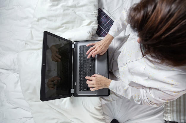 Femme adulte travaillant à la maison à pijama