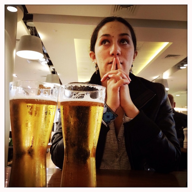 Une femme adulte avec des verres de bière dans un pub.